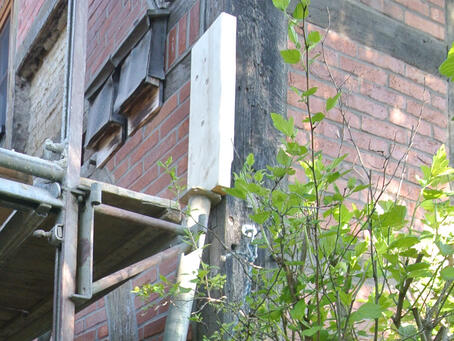 Große Holzklöthe werden als Halter für die Bauwerksstützen angebracht