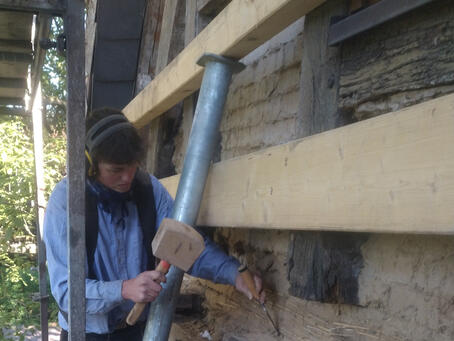 Große Holzklötze werden als Halter für die Bauwerksstützen angebracht
